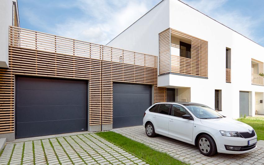 garážová vrata v moderním dřevem obloženém domě, auto před garáží