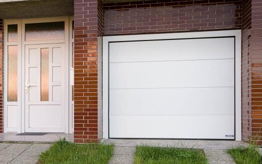 Bílé dveře a garážová vrata usazená v kabřincovém obložení