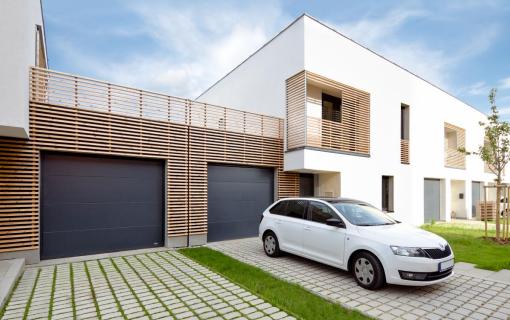 antracitová sekční vrata v dřevěném obkladu, moderní dům, auto